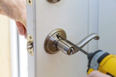 handyman repair the door lock in the worker's hands installing new door locker