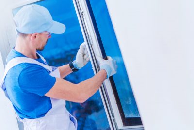 Window Replacement Installation by Professional Caucasian Construction Worker. Home Building or Remodeling Photo Concept.
